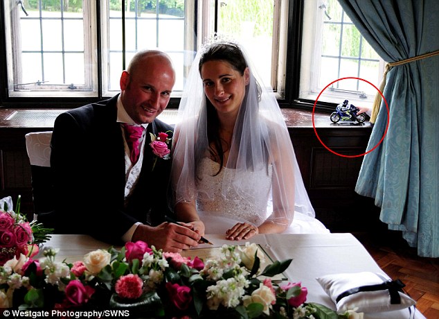 This snap of the couple signing the marriage register appears to feature a ghostly hand clutching a toy motorbike - but it