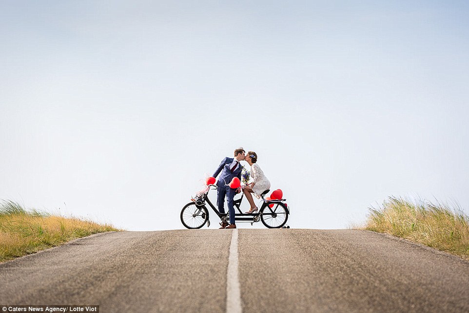 A cute couple stop for a kiss as in the Netherlands in this romantic photograph taken by Lotte Viot 