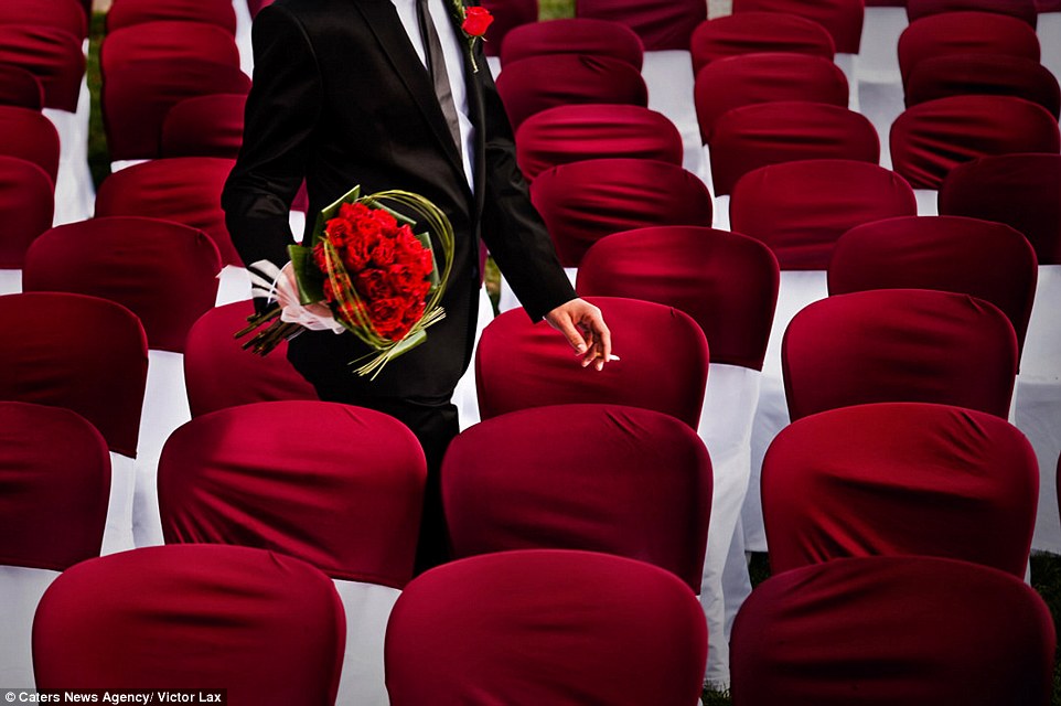A groom puffs on a cigarette and carries his bride bouquet as he walks through an empty ceremony in this snap taken by Victor Lax in Barcelona 