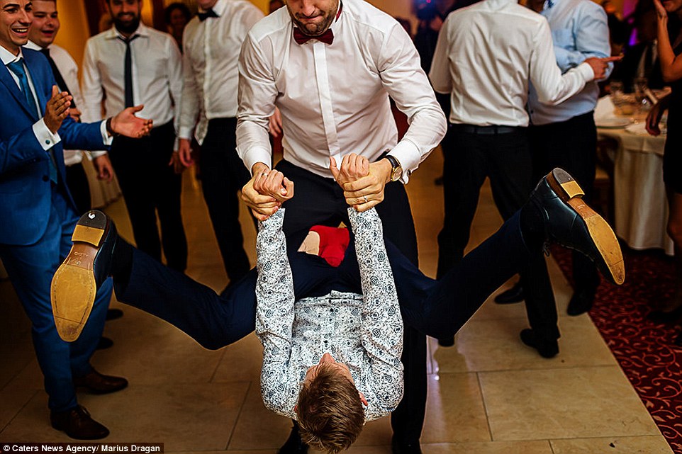 A same sex couple are seen attempting an ambitious dance move in this charming photograph taken by Marius Dragan in New York 