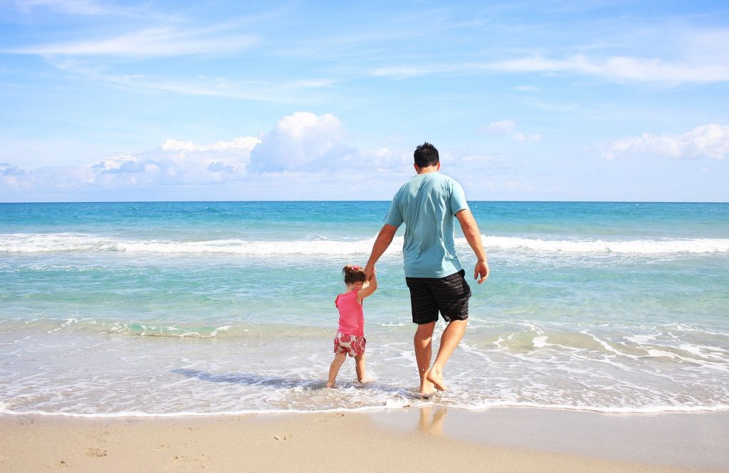 Папа в день рождения гуляет с дочкой по пляжу